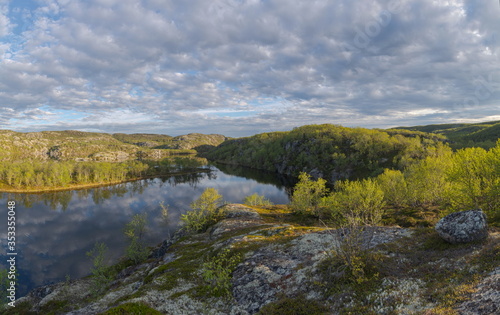 The reservoir is surrounded by hills and forest.Clouds are reflected in the water.Summer landscape. © Moroshka