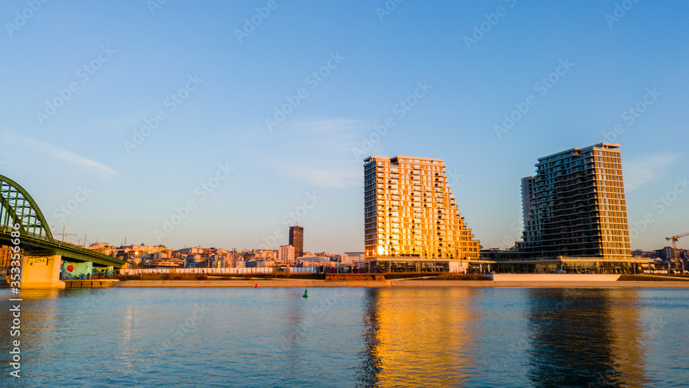 Fototapeta premium View of the city and skyscrapers of Belgrade waterfront under the Old Sava bridge. Cityscape of Belgrade at twilight.