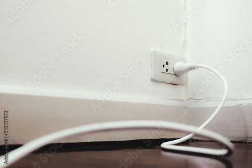 power cord plug of appliances put in the wall socket. electricity usage load in the house. energy power saving concept. photo