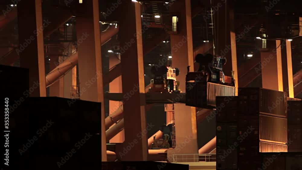 Container ship loading and unloading at night in the Port of Hamburg. Container are moved by a crane Container ship loading and unloading at night in the Port of Hamburg. Container are moved by a crane