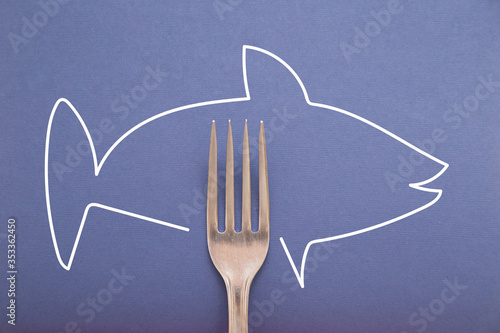 Fork on blue background with hand drawn doodle of fish