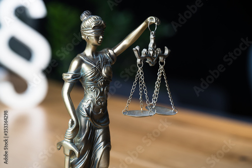 Law and Justice concept. Gavel of the judge, books, scales of justice. Gray stone background.