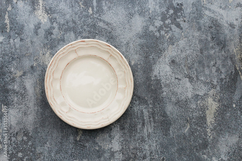 Top view of empty plate on grey, stone background.