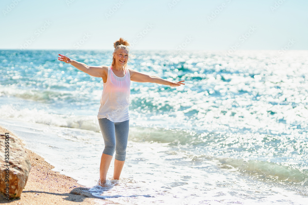 happy senior woman walks by the sea
