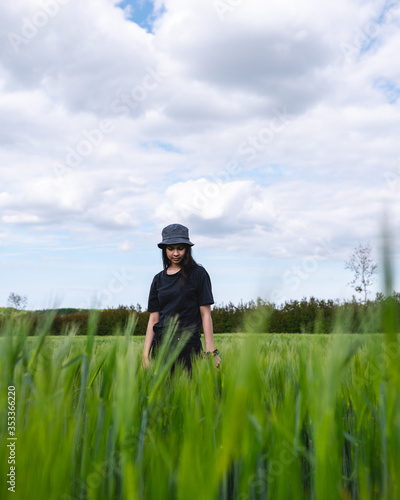 Young posing in green field with grey hat and black tshirt