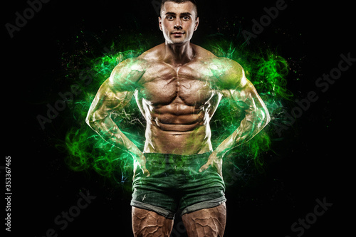 Athlete in green energy lights. Muscular young fitness sports man bodybuilder. Workout in fitness gym. Copy space for fitness nutrition ads.