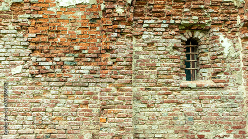 crumbling Church wall of red brick with plaster
