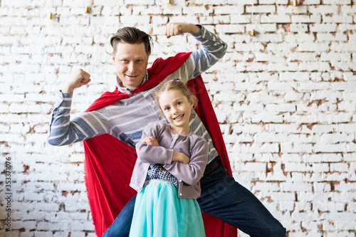 happy father in superhero costume and his daughter