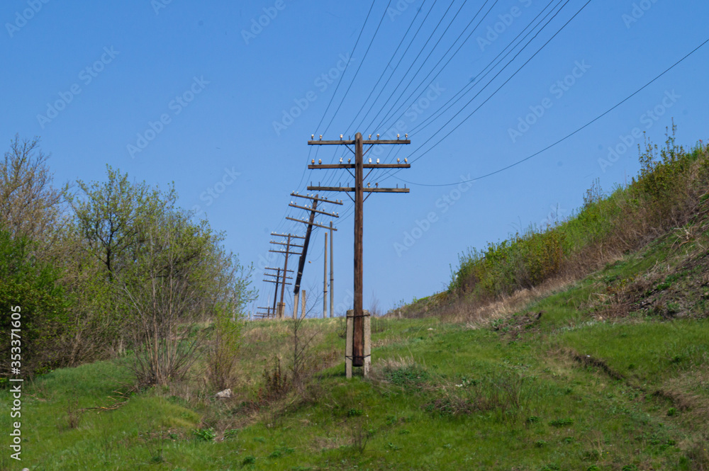 Power lines. Electrification. Electricity. Old electric poles in the forest.
