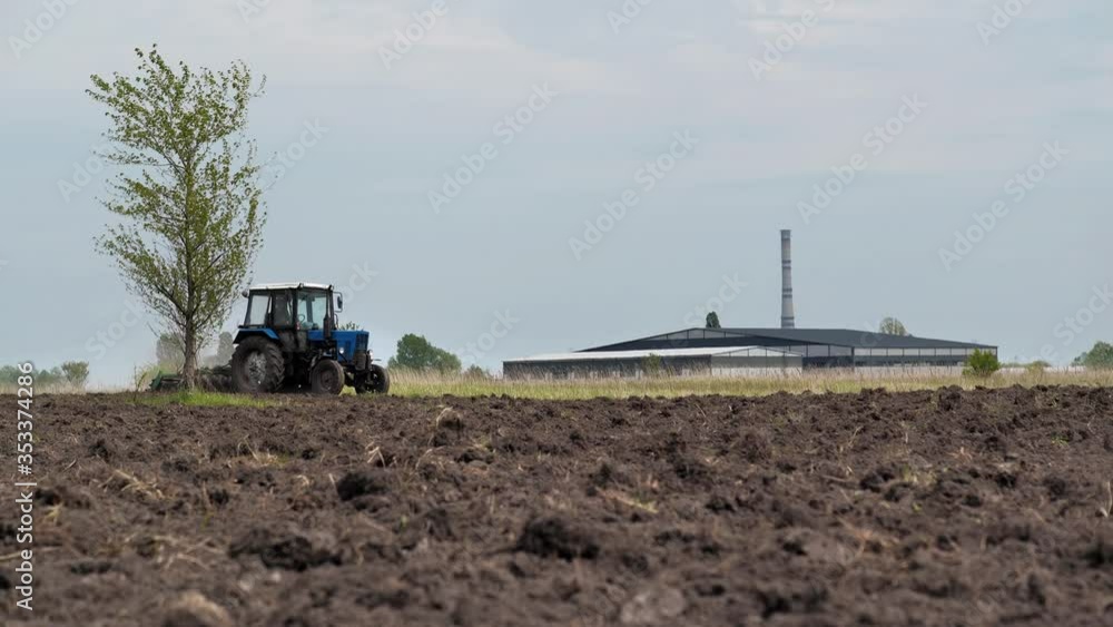 Tractor plowing a field near the city Tractor plowing a field near the city