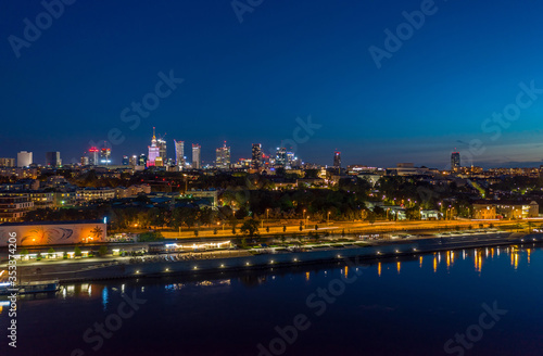 night aerial panorama of Warsaw center across Wisla river with reflection