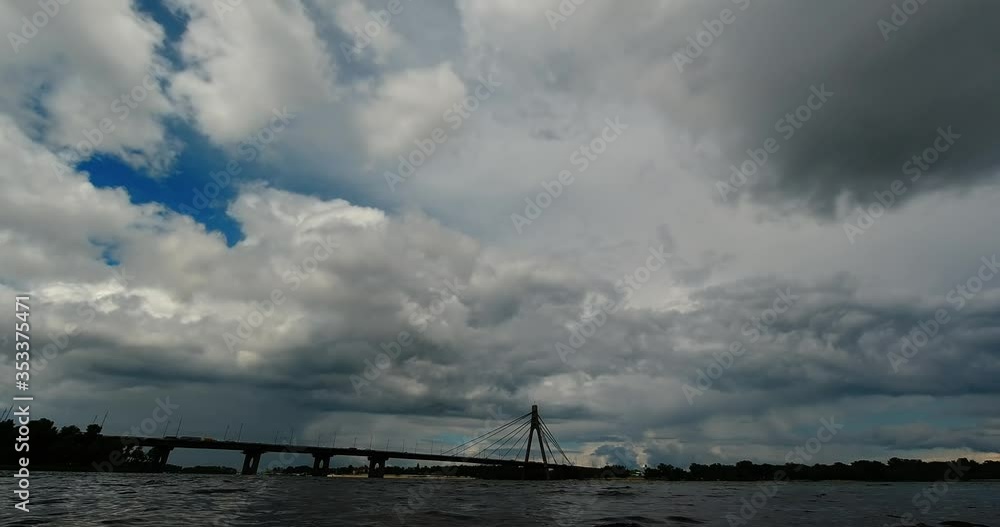 Time lapse clouds over a river and a bridge before a thunderstorm Time lapse clouds over a river and a bridge before a thunderstorm