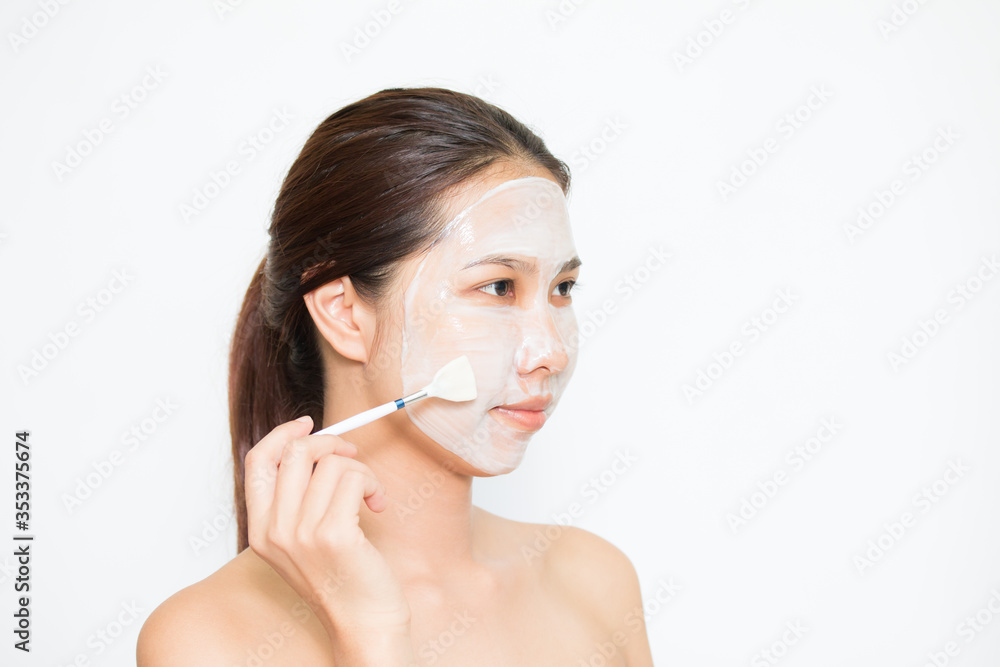 Young beautiful woman applying yogurt facial mask Skin care, beauty treatments on white background Young beautiful woman applying yogurt facial mask Skin care, beauty treatments on white background