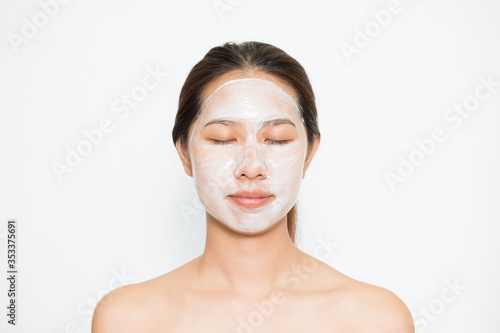 Young beautiful woman applying yogurt facial mask Skin care, beauty treatments on white background