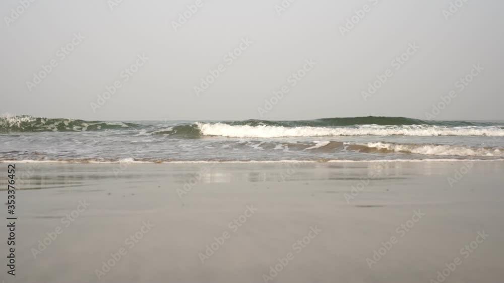 Sandy beach and sea waves. Sea background, coast without people, blue sky Sandy beach and sea waves. Sea background, coast without people, blue sky