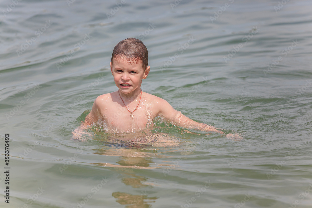Happy little boy is swimming in the lake Happy little boy is swimming in the lake