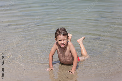Happy little boy is swimming in the lake