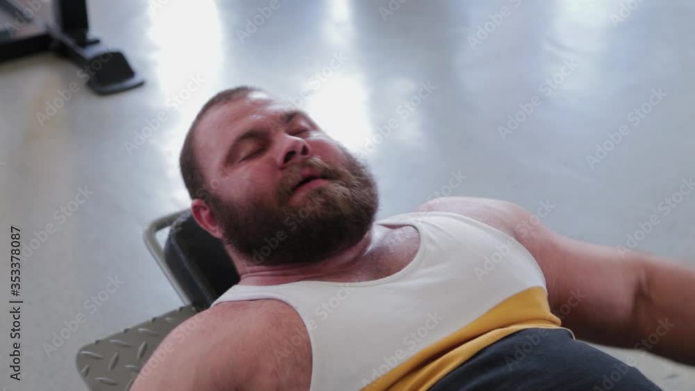 Large and powerful weightlifter trains legs on the simulator in the gym. Large and powerful weightlifter trains legs on the simulator in the gym.