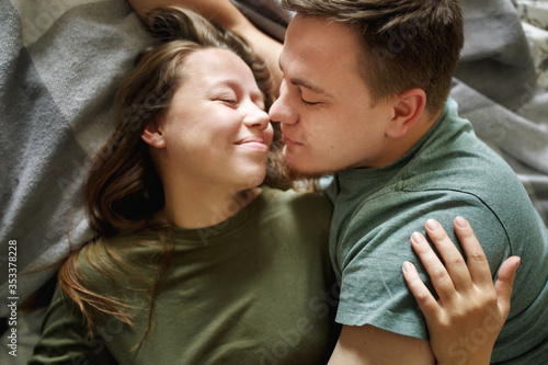 Close-up portrait of affectionate kissing couple in casual clothes, top view