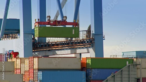 A Gantry crane is loading a container on a ship at daytime in the port of Hamburg / Germany