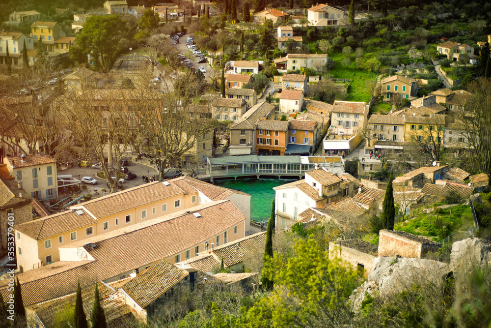 Top view of one of the most beautiful villages of France Fontaine-de-Vaucluse with green river Sorgue. Panoramic view of medieval roofs in Provence, France, in spring