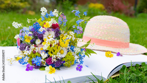 Fototapeta Naklejka Na Ścianę i Meble -  A cute romantic bouquet of wildflowers and meadow flowers of daisy, forget-me-nots, pansies as an art of floristry design. Romantic summer photo for calendars and magazines
