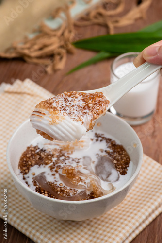 Thai dessert ,Tapioca pearl or Sago pudding with coconut meat in coconut milk on wooden table.