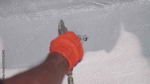 Male hand holds spray gun, uses chemical solution, paints the roof, insulates the roof