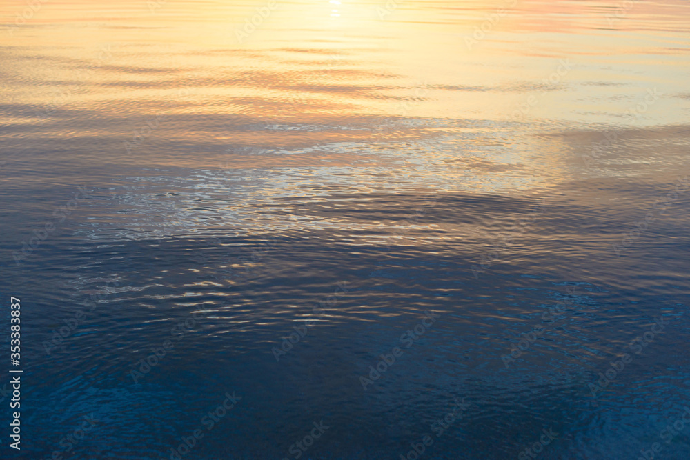 Obraz premium Colorful yellow and blue water surface with ripples on the sea.