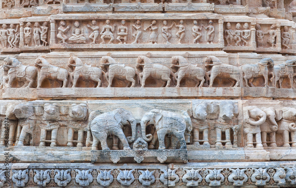 Bas-relief with dancing Apsaras, musicians, horses and elephants at famous ancient Jagdish Temple in Udaipur, Rajasthan, India