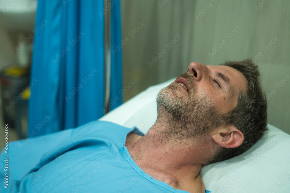 Obraz premium scared and worried man in pain at hospital room - attractive injured man lying on bed suffering painful problem sick and stressed after suffering accident or serious disease