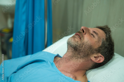 scared and worried man in pain at hospital room - attractive injured man lying on bed suffering painful problem sick and stressed after suffering accident or serious disease