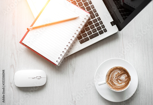 Top view of Laptop or Notebook Computers , pencil , and cup of coffee on white wooden table.