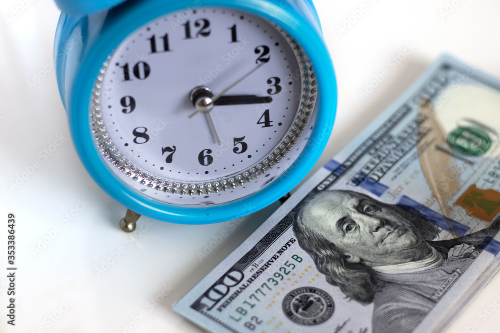 image of money and alarm clock close-up image of money and alarm clock close-up