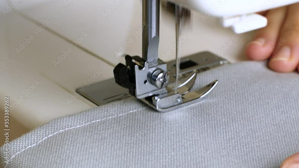 Closeup of woman hands with gray fabric sewing with a sewing machine. Women's hands sew on a sewing machine. Fashion clothes tailoring.
Closeup of woman hands with gray fabric sewing with a sewing machine. Women's hands sew on a sewing machine. Fashion clothes tailoring.