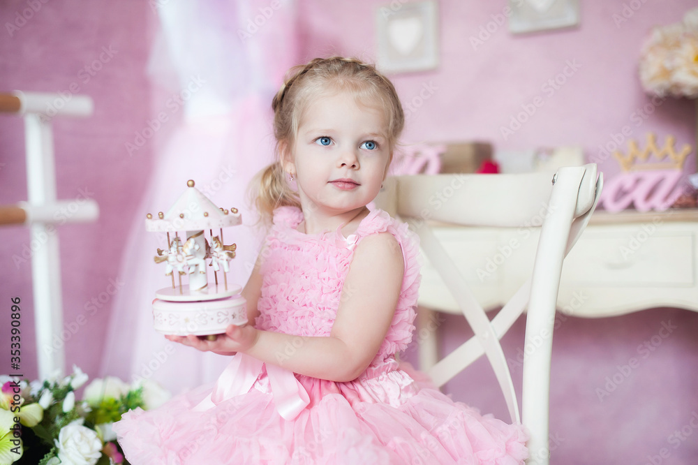Little girl holding a musical toy carousel. The child receives a gift. Vintage musical carousel toy. indoors ballet hall class room Little girl holding a musical toy carousel. The child receives a gift. Vintage musical carousel toy. indoors ballet hall class room