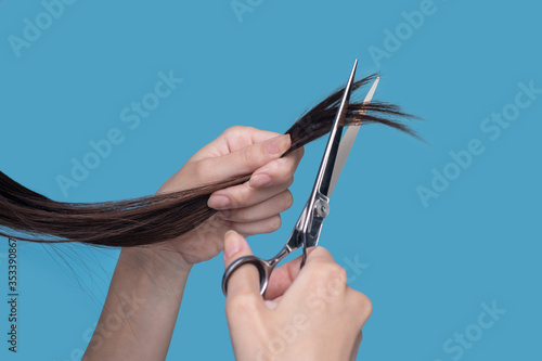 Close up picture of womans hands cutting hair