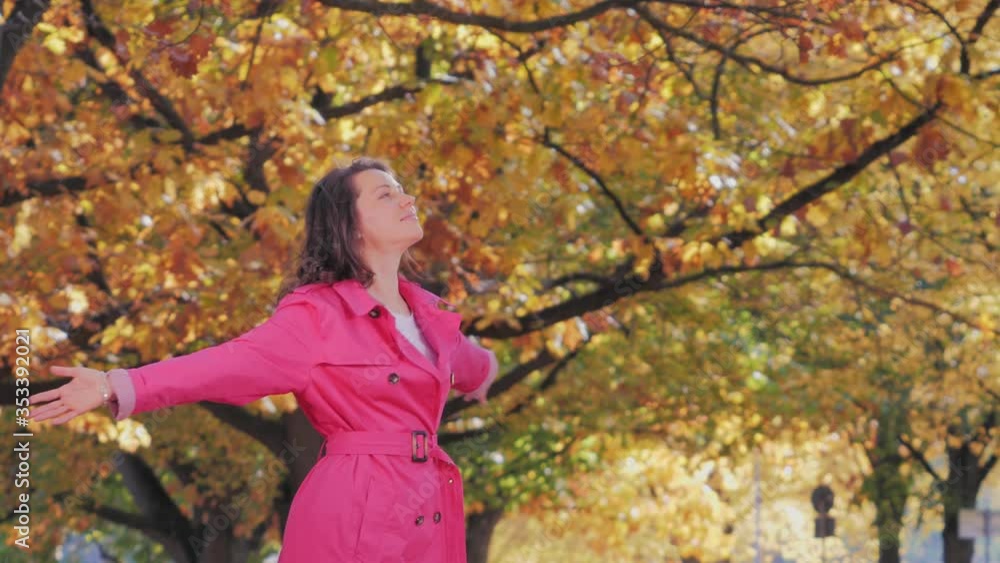 Happy beautiful woman in fall park with arms raised up Happy beautiful woman in fall park with arms raised up