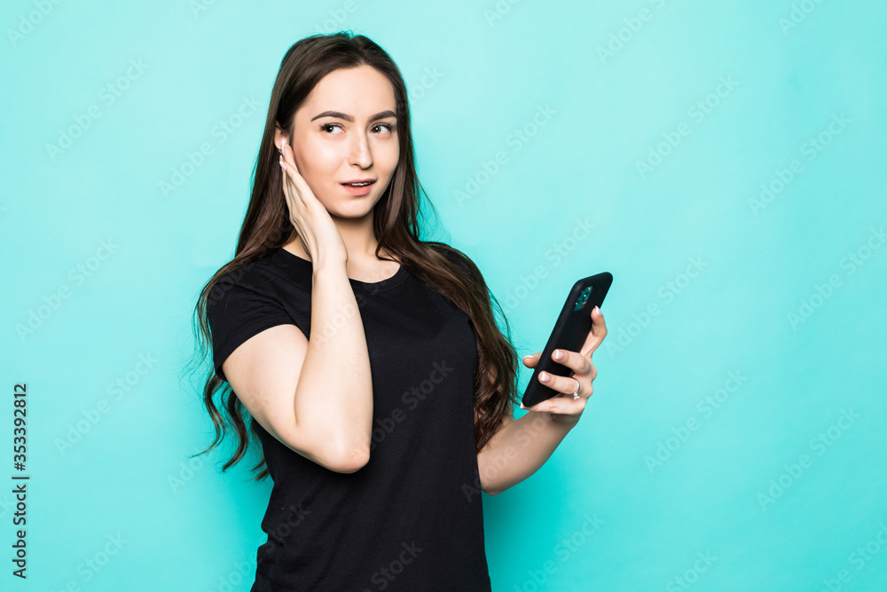 Funny young woman posing isolated on blue turquoise background studio portrait. People lifestyle concept. Mock up copy space. Listen music with air pods, keeping eyes closed Funny young woman posing isolated on blue turquoise background studio portrait. People lifestyle concept. Mock up copy space. Listen music with air pods, keeping eyes closed