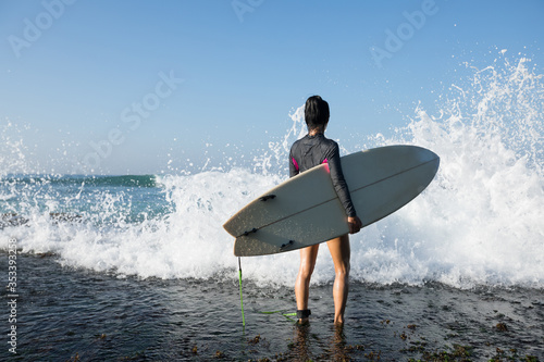 Canvas Print Woman surfer with surfboard going to surf on seaside