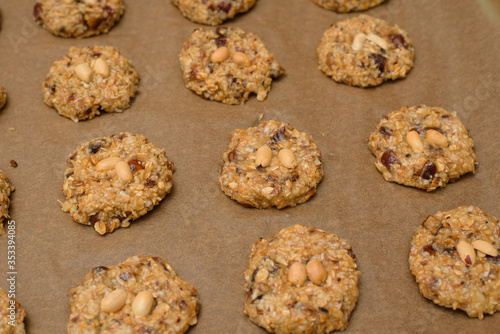 homemade oatmeal cookies with dates  peanuts   coconut shavings on a baking tray  close-up. the view from the top