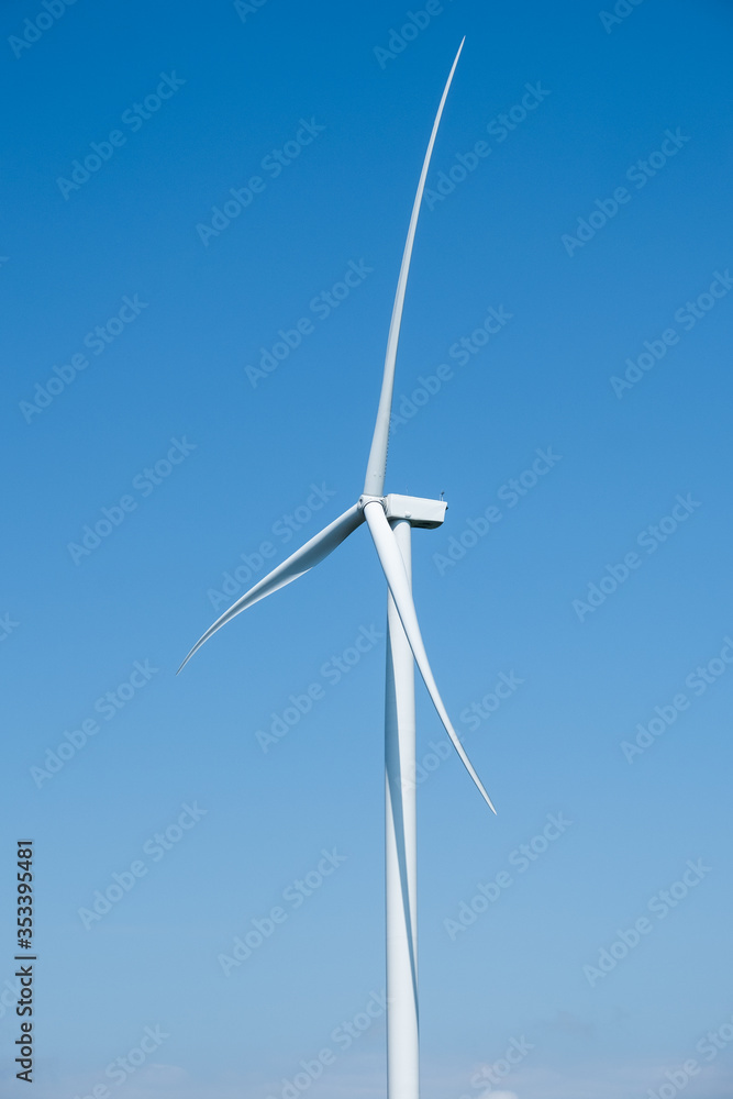 Electricity generating wind turbines with blue sky in background Electricity generating wind turbines with blue sky in background