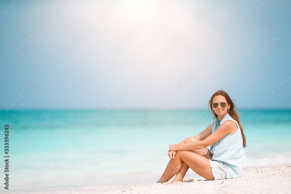 Young beautiful woman having fun on tropical seashore. Happy girl background the blue sky and turquoise water in the sea