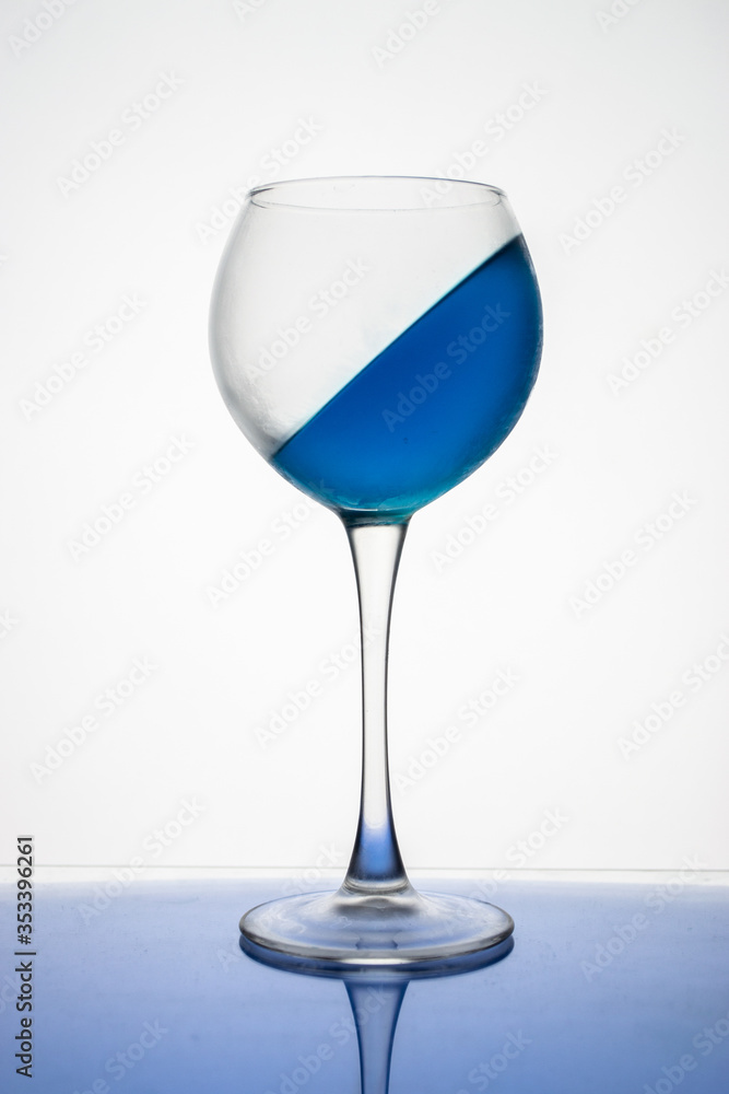 Blue ice drink in a glass is frozen at an angle on a white background Blue ice drink in a glass is frozen at an angle on a white background