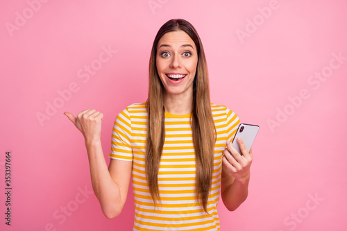 Close-up portrait of her she nice attractive lovely pretty amazed glad cheerful cheery girl using digital cell demonstrating new novelty copy space isolated over pink pastel color background © deagreez
