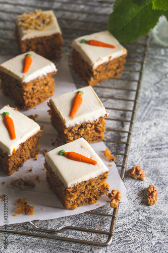 pieces of carrot cake with walnuts with icing cream on a light background. tinting. selective focus