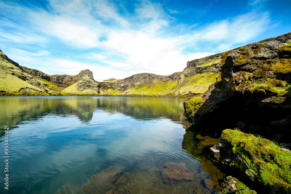 Volcanic lake inside of a crater in Iceland. Volcanic crater lake in southern Iceland. Highland of Iceland. Beautiful crater lake with a turquoise water color covered with green moss