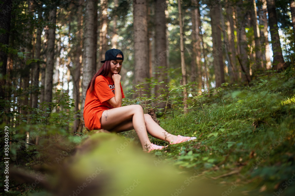 Sad young european girl sitting in a forest Sad young european girl sitting in a forest