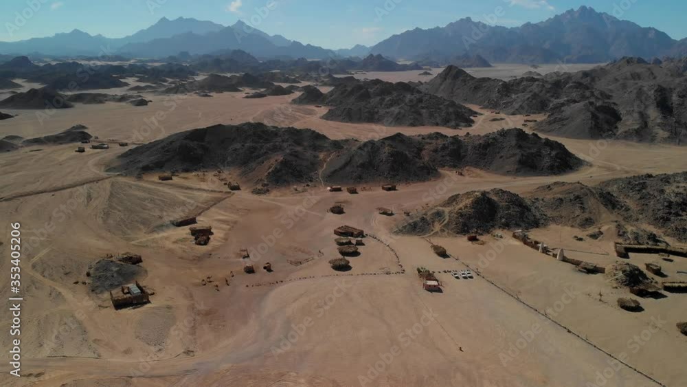 Top view of the Sahara desert, desert mountains. Wooden Bedouin houses. Sands. Tourists walk around the village. Top view of the Sahara desert, desert mountains. Wooden Bedouin houses. Sands. Tourists walk around the village.