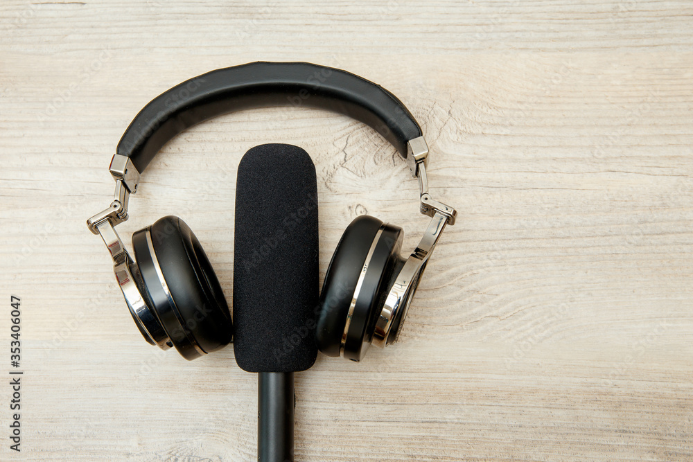 Wireless headphones and microphone on a wooden table. Wireless headphones and microphone on a wooden table.